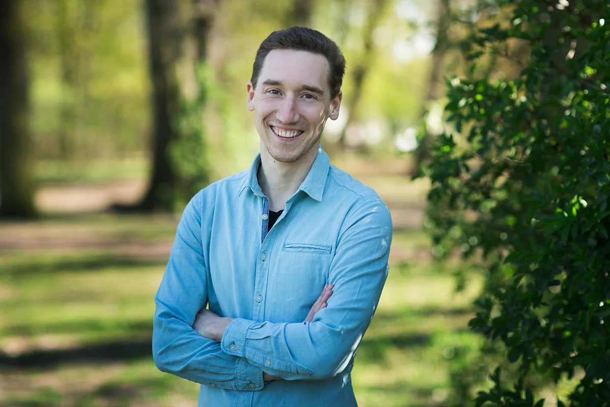 Andreas Jansen, Gründer von 8Breath, steht im hellblauen Hemd mit verschränkten Armen im Freien und lächelt in die Kamera